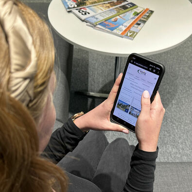 A woman discovers the digital holiday companion my Achensee on her mobile phone.