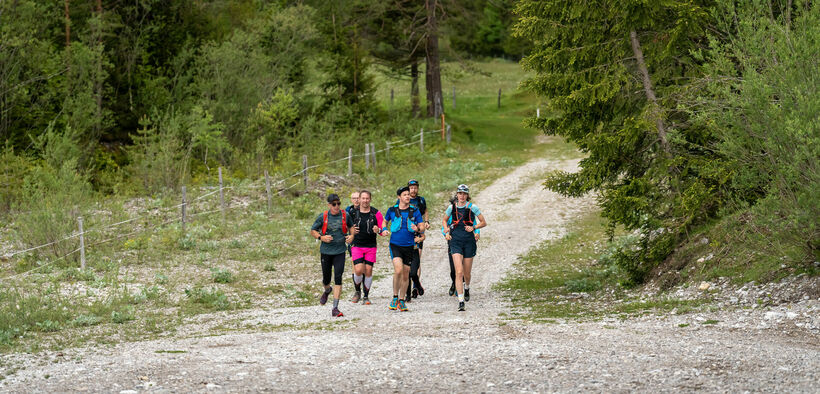 A group of runners out and about on gravel paths in the natural landscape of Lake Achensee.