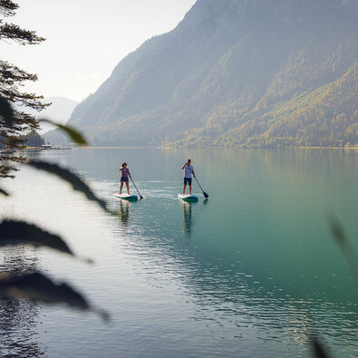 SUP at Lake Achensee Explore Lake Achensee at a leisurely pace as you stand on a large surfboard and use a paddle to propel yourself through the water.