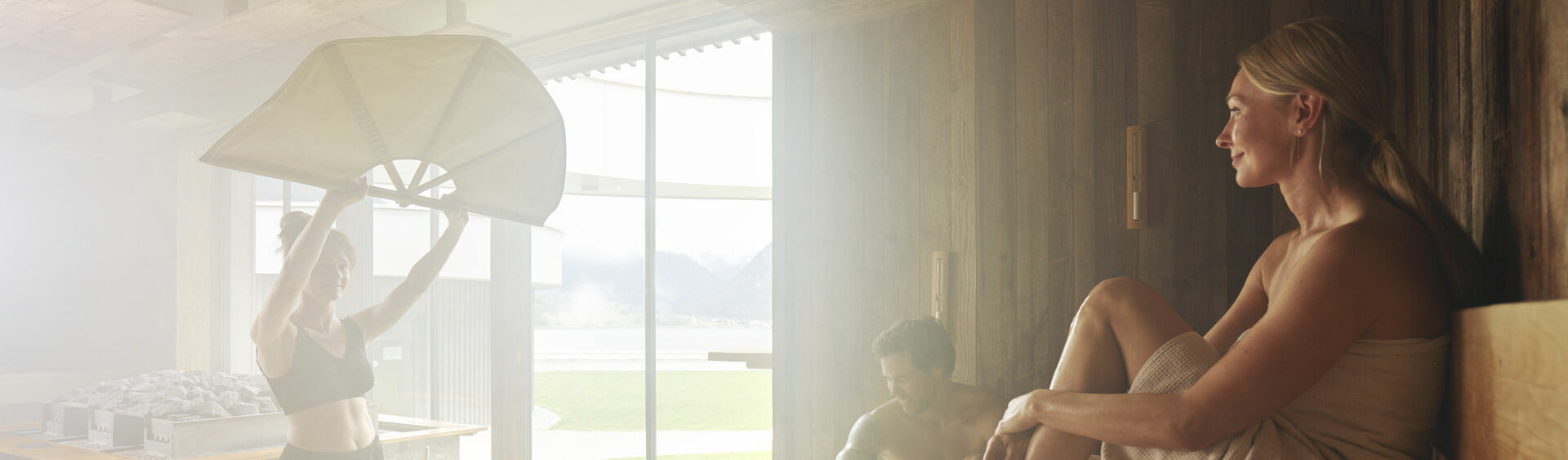 A couple is enjoying the sauna infusion in the wellness area of Atoll Achensee.