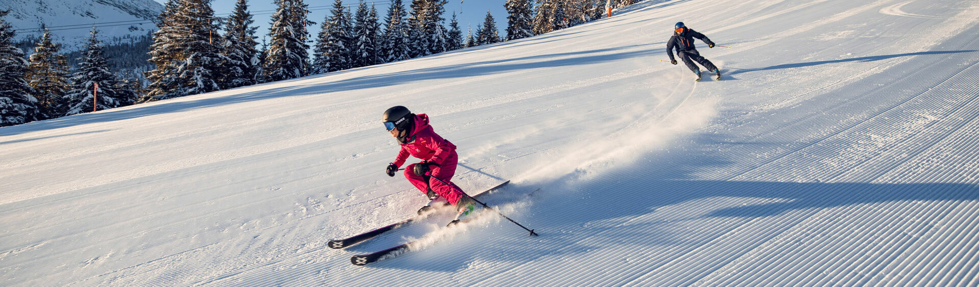 Two skiers enjoy a day of skiing in brilliant sunshine in the Hochalmlifte Christlum ski area in Achenkirch am Achensee.