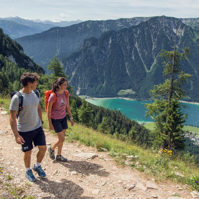 Hiking in the Rofan mountains A couple walks along a hiking trail in the Rofan Mountains enjoying the beautiful wildflower meadows.