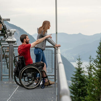 The Karwendel mountain railroad enables wheelchair users to enjoy a carefree ride in the mountains. Two friends enjoy the view of the Achensee region from the Zwölferkopf.