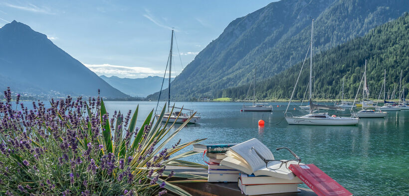 achensee.literatour Im Zuge des Literaturfestivals „achensee.literatour“ wurden viele fesselnde Bücher vor einer atemberaubenden Kulisse in Szene gesetzt, begleitet vom malerischen Achensee, Segelbooten und dem majestätischen Ebner Joch im Hintergrund.