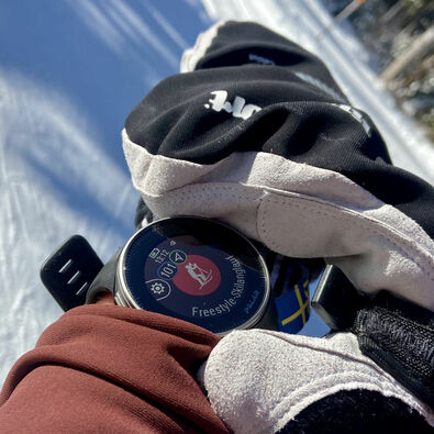 A cross-country skier starts his sports watch to record his run.