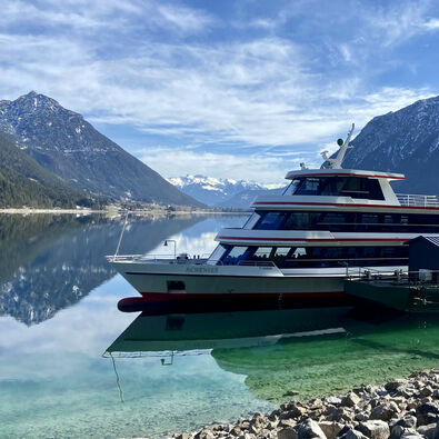 Achenseeschifffahrt in Pertisau am Achensee The Achenseeschifffahrt docks in Pertisau on Lake Achensee. In the background, you can spot snow-dusted mountains like the Ebner Joch.